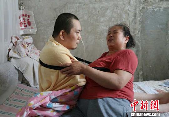 身體日漸衰老的梁青蘭每次幫兒子翻身、坐立，全身的衣物都要濕透一次?！∩忻鱾b 攝