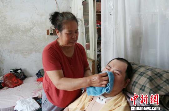 每次喂完食物后，梁青蘭都要仔細地幫兒子清理干凈?！∩忻鱾b 攝