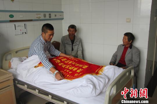 被救的李忠起、張總鳳夫婦看望受傷后的李運(yùn)飛?！⊥粲?攝