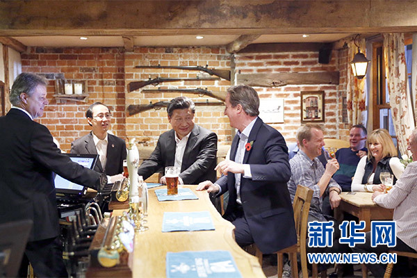 這是會(huì)晤結(jié)束后，習(xí)近平在卡梅倫陪同下乘車(chē)前往當(dāng)?shù)匦℃?zhèn)體驗(yàn)酒吧文化。新華社記者 鞠鵬 攝