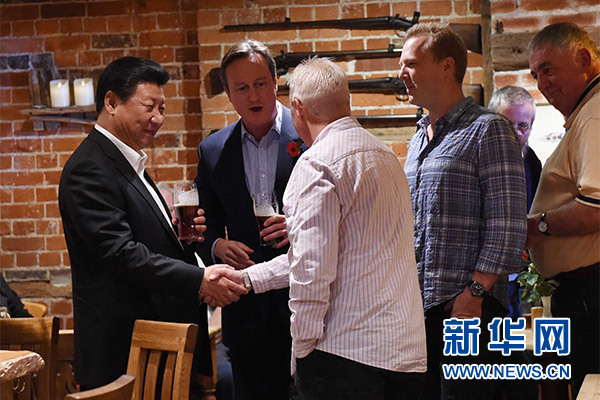 這是習(xí)近平與卡梅倫飲啤酒，并同當(dāng)?shù)孛癖娊徽劇Ｐ氯A社記者 饒愛(ài)民 攝